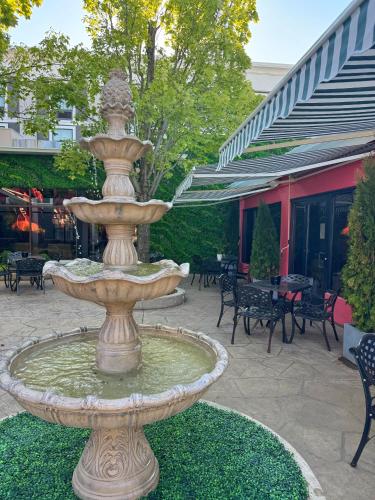 a fountain in a courtyard with tables and chairs at Hotel Gurnee in Gurnee