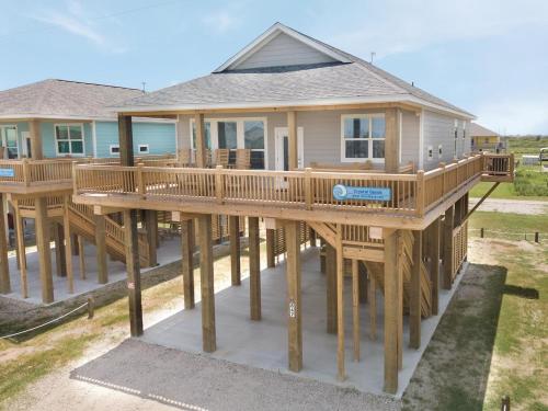a house with a large deck in front of it at Crystal Sands in Crystal Beach