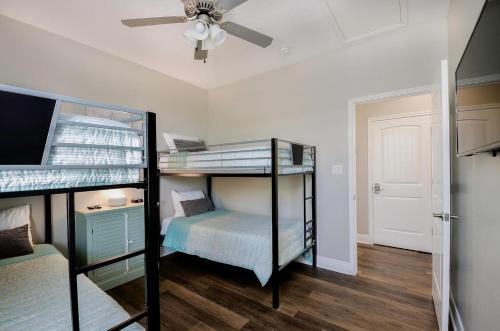 two bunk beds in a room with a ceiling fan at Crystal Sands in Crystal Beach