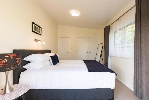a bedroom with a white bed and a window at Seabeds in Paihia