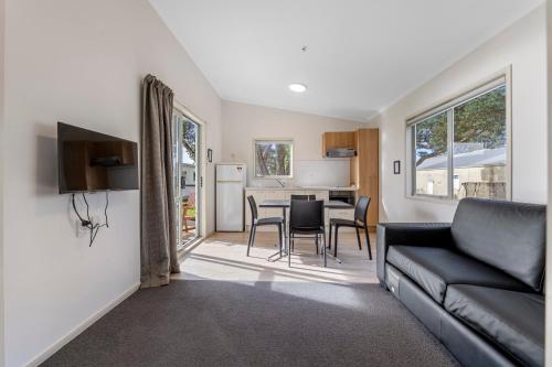 a living room with a couch and a table at Belt Road Seaside Holiday Park in New Plymouth