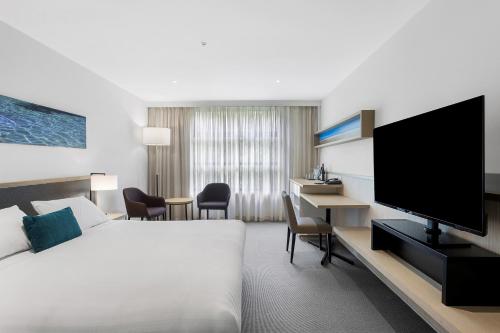 a hotel room with a bed and a flat screen tv at Quarters at Flinders Hotel in Flinders