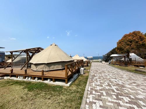 a group of tents sitting next to a brick road at 瀬戸内リゾートベッセルおおち in Higashikagawa