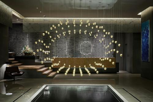 a lobby with a bench and a large circle of lights at THE AMNIS, a Luxury Collection Hotel, Kaohsiung in Kaohsiung