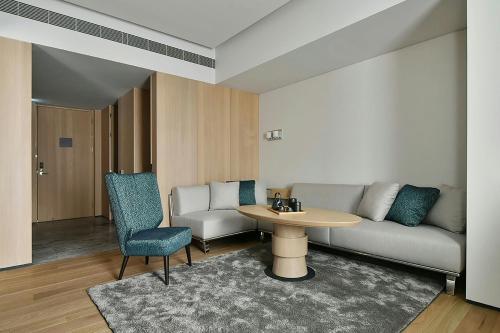 a living room with a couch and a table at THE AMNIS, a Luxury Collection Hotel, Kaohsiung in Kaohsiung