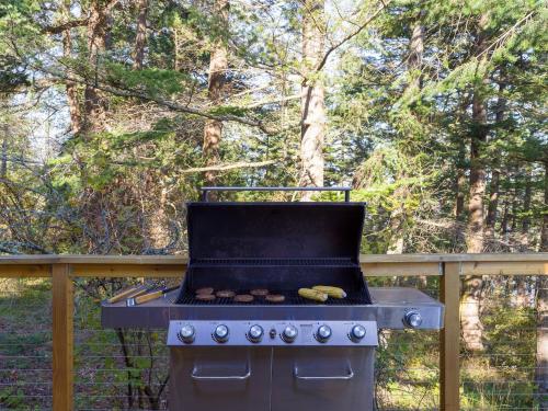 a grill with hamburgers on it in a yard at Waterfront Privacy, Pet-friendly, Close To Trails in Olga