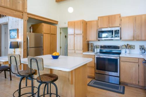 a kitchen with wooden cabinets and a island with bar stools at Waterfront Privacy, Pet-friendly, Close To Trails in Olga