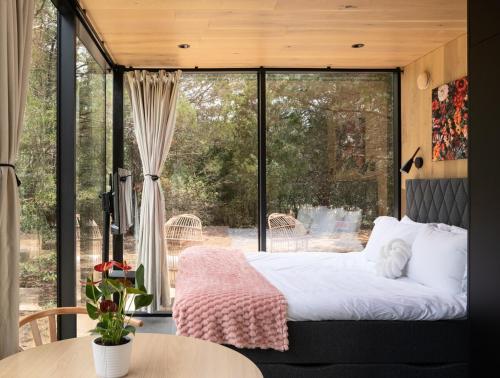 a bedroom with a bed and a large window at Lakeside ÖÖD Mirror Cabin #1 - Nature Getaway in Bastrop