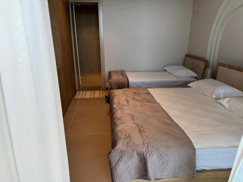 three beds in a small room with a window at Uzeiri Guest Hotel in Borsh