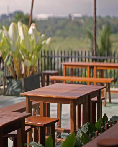 a group of wooden tables and benches with a fence at Kasuari Exotic Resort Magelang in Magelang