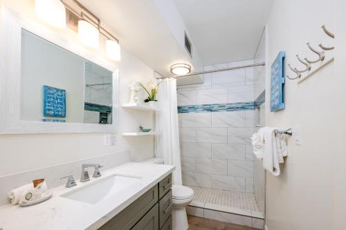 カハナにあるNEW-Maui is Calling - Ocean View Modern Chic West Maui Retreatの洗面台とシャワー付きの白いバスルーム