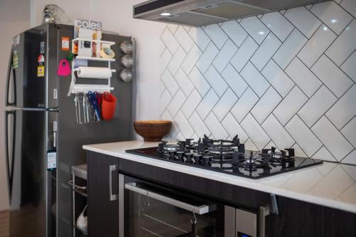 a kitchen with a stove and a refrigerator at Treeby's Finest Family Home 4bdr 2bth in Perth