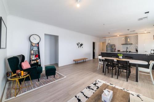 a living room and dining room with a clock on the wall at Treeby's Finest Family Home 4bdr 2bth in Perth