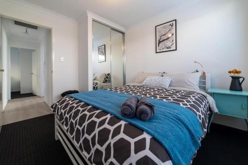 a bedroom with a bed with a blue blanket at Treeby's Finest Family Home 4bdr 2bth in Perth