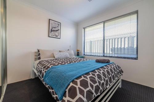 a bedroom with a bed and a large window at Treeby's Finest Family Home 4bdr 2bth in Perth