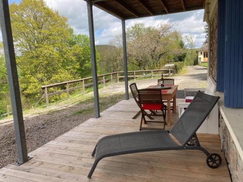 a wooden porch with a table and chairs on it at Apartment in Cuzy with Heated Pool in Cuzy