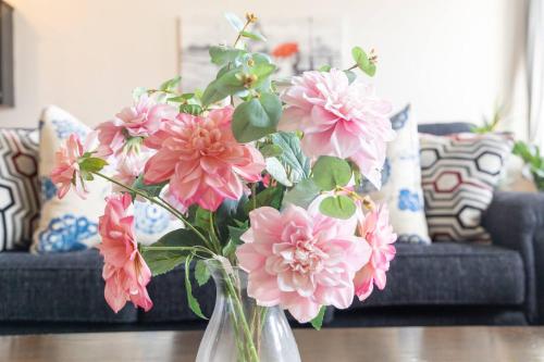 a vase filled with pink flowers on a table at Greely Gaslamp - Loft W Parking & 4 Beds #401 in San Diego
