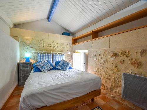 MonprimblancにあるHoliday Home in Monprimblanc with Pool & Vineyardsのベッドルーム1室(青い枕のベッド1台付)