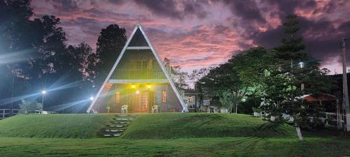 a house with a pyramid shaped building on a hill at night at Sítio Vista Alegre in São Luiz do Paraitinga