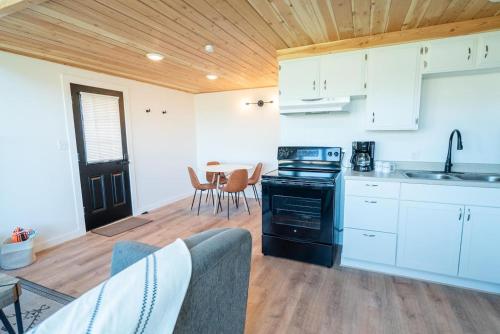 a kitchen with white cabinets and a table with chairs at Tidal House #10 - Ocean Shores Chalet in Ocean Shores