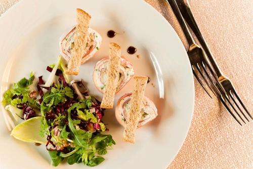 a white plate with a sandwich and salad on it at Hotel Stefaner in Tires