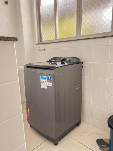 a washing machine in a bathroom with a window at Apê com vista para o mar e clima animado in Vitória