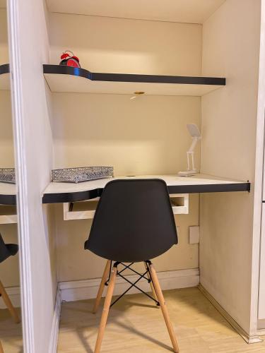 a desk and a chair in a room at Apê com vista para o mar e clima animado in Vitória
