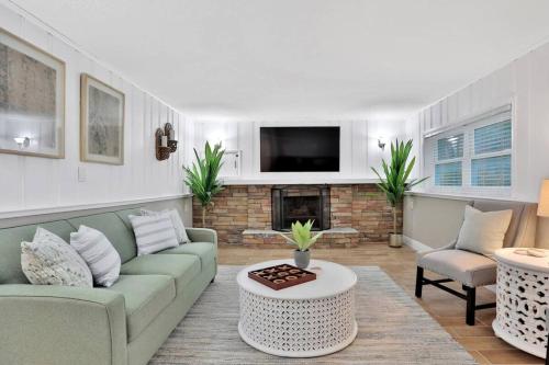 a living room with a couch and a fireplace at Kiss The Wave - Spacious 4br3ba, Wpoolhot Tub in Indian Harbour Beach