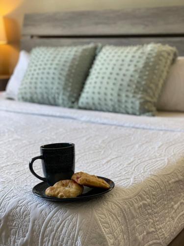 a tray with a cup of coffee and pastries on a bed at Kiss The Wave - Spacious 4br3ba, Wpoolhot Tub in Indian Harbour Beach