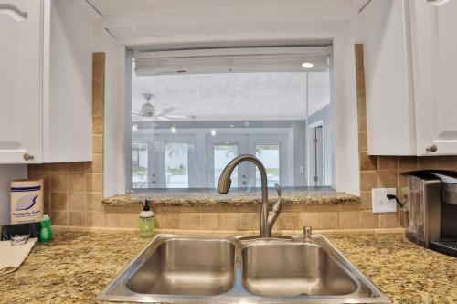 a kitchen sink with a window in a kitchen at Kiss The Wave - Spacious 4br3ba, Wpoolhot Tub in Indian Harbour Beach