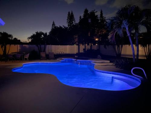 a large blue swimming pool at night at Kiss The Wave - Spacious 4br3ba, Wpoolhot Tub in Indian Harbour Beach