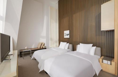 a hotel room with two beds and a television at Park Hyatt Shanghai in Shanghai