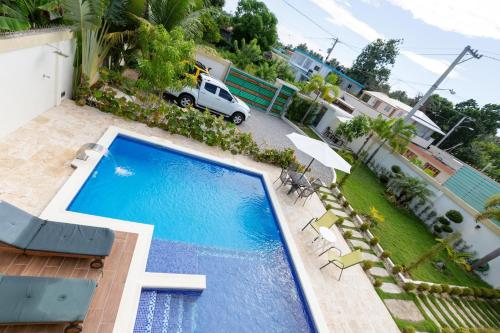 an overhead view of a swimming pool with chairs and an umbrella at Villa Alida Nagua Pool Beach Dailymaid & Bbq in Matancita
