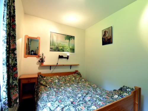 a small bedroom with a bed and a mirror at Cozy Forest Chalet in Ovifat in Ovifat