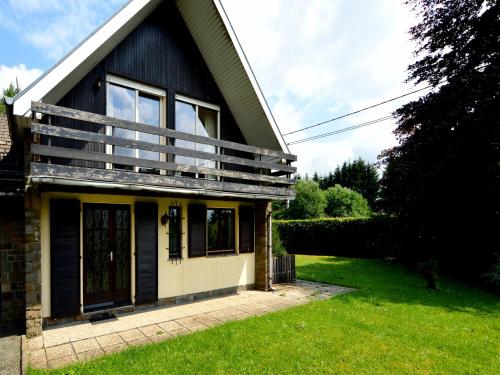a house with a balcony on the side of it at Cozy Forest Chalet in Ovifat in Ovifat