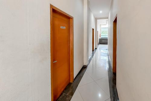 a hallway with a wooden door in a building at Hotel Cemara Hijau Mitra RedDoorz in Bandung