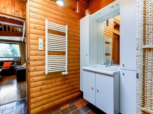 Un baño con lavabo y pared de madera. en Nature retreat for families, en Lignières