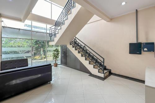a lobby with a staircase in a building at Hotel Cemara Hijau Mitra RedDoorz in Bandung