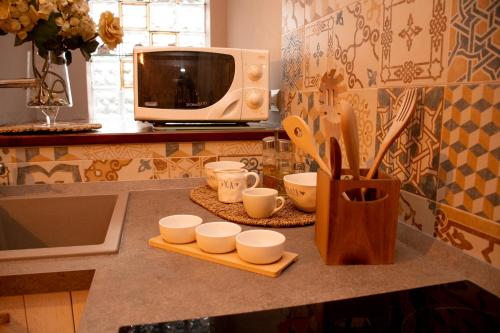 a kitchen counter with cups and a microwave at The Oaks in Spigno Saturnia