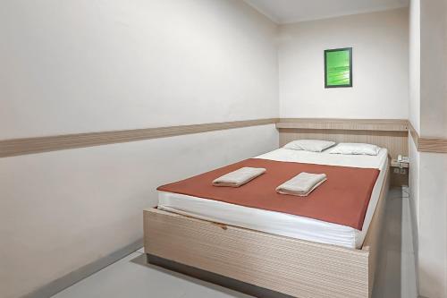 a small bedroom with a bed with two towels on it at Hotel Cemara Hijau Mitra RedDoorz in Bandung