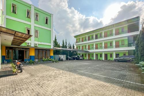 a parking lot in front of some buildings at Hotel Cemara Hijau Mitra RedDoorz in Bandung