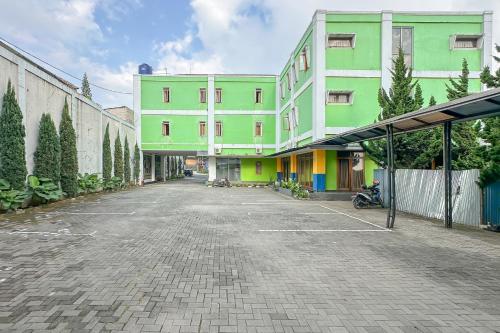 an empty parking lot in front of a building at Hotel Cemara Hijau Mitra RedDoorz in Bandung