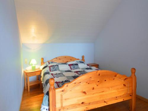 a wooden bed in a bedroom with a wooden floor at Spacious Farmhouse, Libramont in Libramont