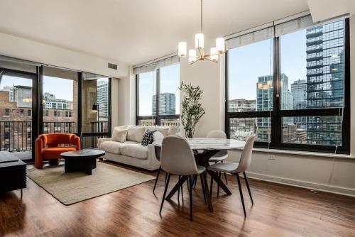a living room with a couch and a table with chairs at Boulevard Stays Walk Everywhere 5 mins to Magnificent Mile River North 05 in Chicago