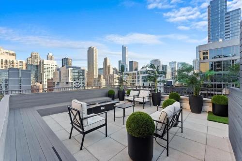 a patio with chairs and a table on a roof at Boulevard Stays Walk Everywhere 5 mins to Magnificent Mile River North 05 in Chicago
