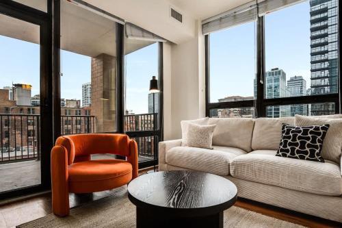 a living room with a couch and a chair at Boulevard Stays Walk Everywhere 5 mins to Magnificent Mile River North 05 in Chicago