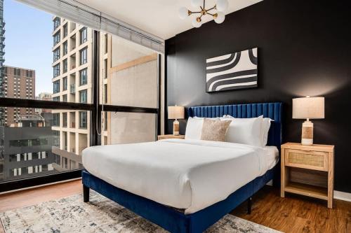 a bedroom with a large bed and a large window at Boulevard Stays Walk Everywhere 5 mins to Magnificent Mile River North 05 in Chicago