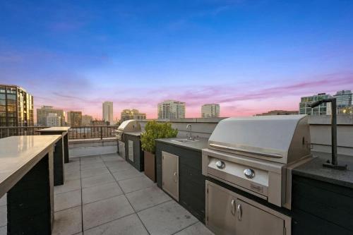 a grill on a rooftop with a view of a city at Boulevard Stays Walk Everywhere 5 mins to Magnificent Mile River North 05 in Chicago