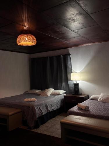 a bedroom with two beds and a lamp and a ceiling at Napoli Centro in Santa Ana