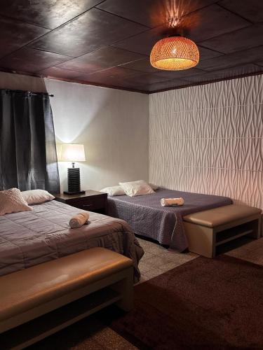 a bedroom with two beds and a lamp and a light at Napoli Centro in Santa Ana